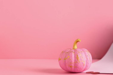 Renkli arkaplanda pembe boyalı balkabağı