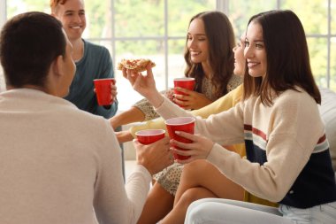 Evde bira ve pizzalı bir grup genç arkadaş.