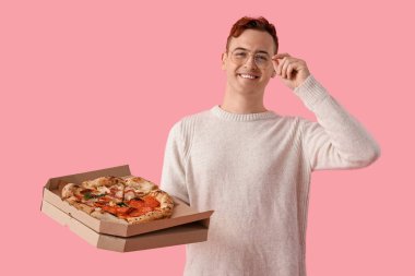 Pembe arka planda lezzetli pizzası olan genç adam.