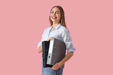 Pembe arka planda doküman klasörleri olan genç iş kadını