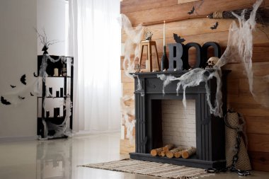 Cadılar Bayramı için dekoratif şömine rafıyla dekore edilmiş oturma odasının içi.