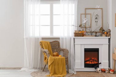 Şömineli, hasır koltuklu ve Cadılar Bayramı dekorasyonlu festival salonu.