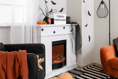 Şömineli, siyah koltuklu ve cadılar bayramı dekorasyonlu festival salonu.