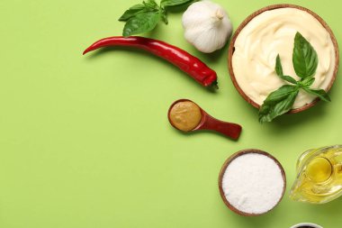 Bir kase taze mayonez ve yeşil arka planda malzemeler.