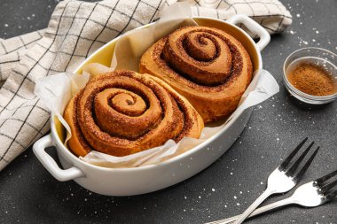 Siyah arka planda lezzetli tarçınlı fırın yemeği.