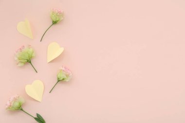 Kağıt kalpler, pembe arka planda karanfil çiçekleri. Ulusal Tatlı Gün