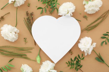 Kahverengi arka planda karanfil çiçekleri olan kağıt kalp. Ulusal Tatlı Gün