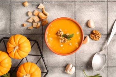 Cevizli balkabağı kremalı çorba, maydanoz ve gri fayanslı kızarmış ekmek.