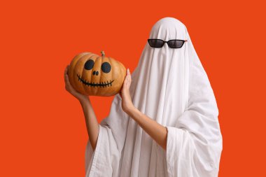 Cadılar Bayramı kostümlü genç bir kadın hayalet ve balkabaklı güneş gözlüğü.