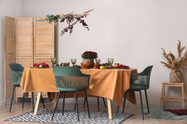 Modern yemek odasında bir buket çiçek ve balkabağı ile güzel bir sonbahar masası.