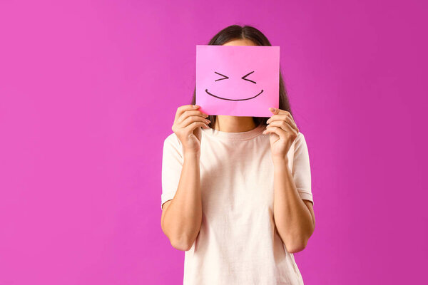 Молодая женщина с бумажной улыбкой на фиолетовом фоне