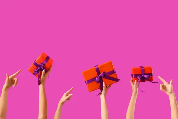 Women pointing at Halloween gifts on purple background