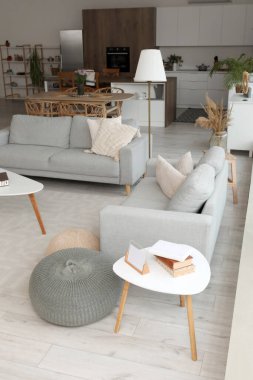 Gri kanepeleri ve kahve sehpası olan açık mutfak.