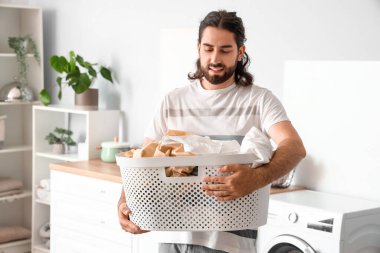 Çamaşır sepetli genç adam.