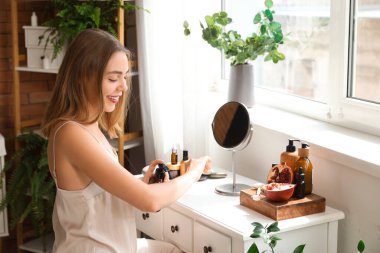 Genç bir kadın banyoya krem sürüyor.