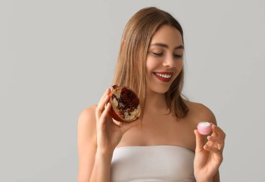 Nar ve krema dolu arka planda genç bir kadın.