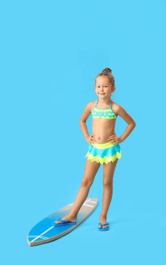 Mavi arka planda sörf tahtası olan küçük kız.