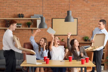 Ofis partisinde pizza yiyen bir grup genç iş arkadaşı.