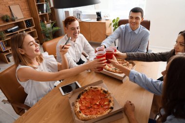 Ofis partisinde pizza içen bir grup genç iş arkadaşı.