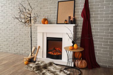 Cadılar Bayramı balkabaklı şömine ve gri tuğla duvarın yanında yanan mumlar.