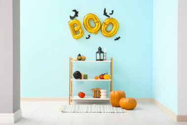 Cadılar Bayramı için dekore edilmiş oturma odasının içinde balonlar ve raf ünitesi var.