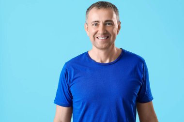 Mavi arka planda mutlu olgun bir adamın portresi