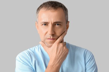 Gri arka planda olgun bir adamın portresi