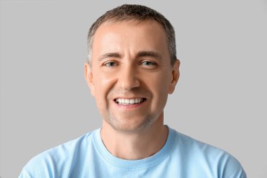 Gri arka planda mutlu olgun bir adamın portresi