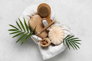 Farklı banyo malzemeleri ve arka planda palmiye yaprakları olan sepet.