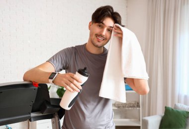 Sportif genç adam eğitimden sonra evde dinleniyor.