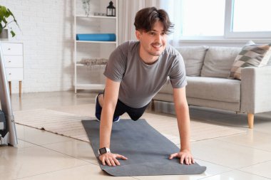 Evde şınav çeken genç bir adam.