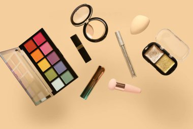 Uçan dekoratif kozmetik soluk turuncu arka planda