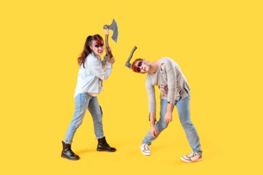 Sarı arka planda baltaları olan korkunç zombiler.