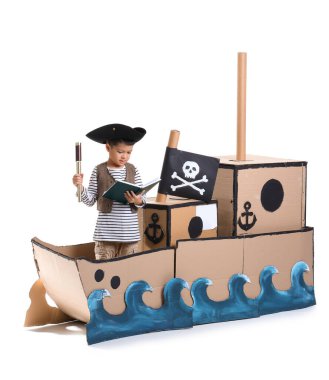 Beyaz arka planda karton gemide macera kitabı olan sevimli küçük bir korsan.