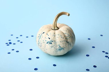 Mavi arka planda boya lekeleri olan Cadılar Bayramı kabağı