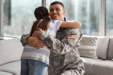 Küçük kızıyla evde kucaklaşan bir asker. Gaziler Günü kutlamaları