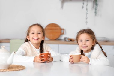 Mutfakta çay içen tatlı küçük kızlar.