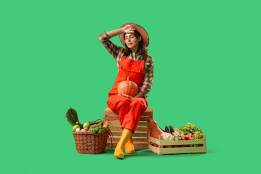 Yeşil arka planda taze sebzeleri olan kadın çiftçi.