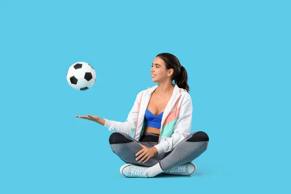 Sportig Ung Kvinna Med Fotboll Sitter Blå Bakgrund — Stockfoto