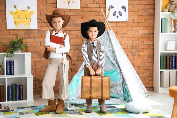 Cute little cowboys with adventure book at home