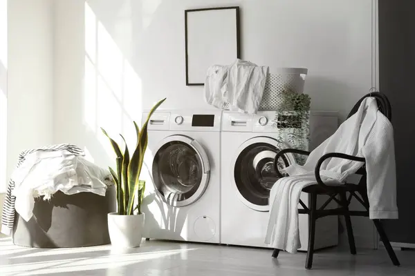 Interior of laundry room with washing machines and dirty clothes