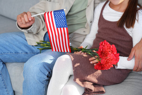 Little girl and her father with USA flag at home, closeup. Veterans Day celebration