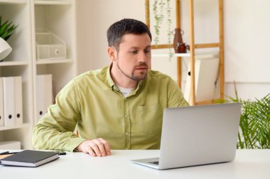 Ofiste çalışan dizüstü bilgisayarı olan adam.