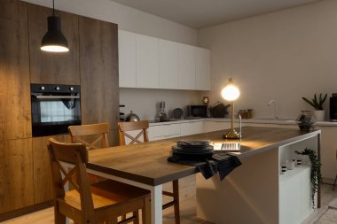 Ada masasında parlayan lambalar ve dizüstü bilgisayarlı modern mutfak.