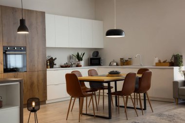 Modern mutfak, yemek masası ve parlayan lambalar.