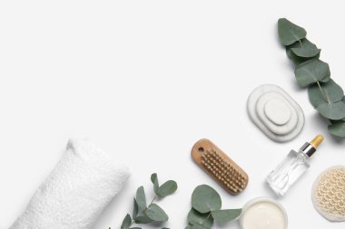 Banyo malzemeleri ve beyaz arka planda okaliptüs dalları olan kompozisyon