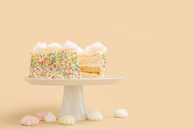 Lezzetli doğum günü pastası ve bej arka planda kremayla durun.