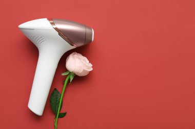 Kırmızı arka planda güzel pembe güllü modern fotoepilatör.