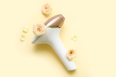 Bej arka planda güzel gülleri olan modern fotoepilatör.