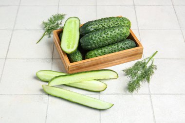 Taze salatalıklı ahşap kutu ve beyaz fayanslı dereotu.